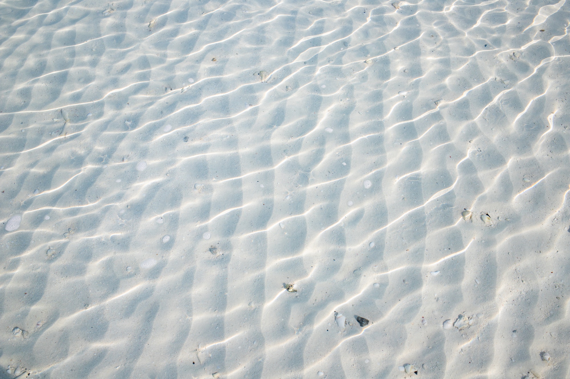 white sand texture in clear sea water